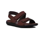 Sandalia de hombre color marrón con dos tiras ajustables con velcro en el empeine y pulsera trasera con cierre de velcro. Cuenta con una base de goma negra ergonómica.