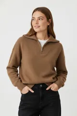 Sweater de tejido punto color marrón, con cuello polo y cierre frontal parcial, de manga larga y diseño holgado.