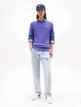 Zapatillas deportivas de estilo vintage Tommy Jeans modelo The Greenwich, confeccionadas en ante color blanco con paneles laterales en azul vibrante y detalles en gamuza gris claro. Presentan cierre con cordones, suela cupsole de goma y logo de la marca en el lateral.