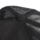 Gorra Adidas tipo trucker color negro, con visera plana, paneles frontales de tela y paneles traseros de malla transpirable. Cuenta con el logotipo del trébol y la inscripción de la marca bordados en relieve al tono en el frente.