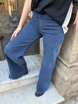 Pantalón de jean estilo wide leg con diseño de paneles y costuras visibles en contraste. Presenta un corte amplio y tiro alto, confeccionado en denim con elasticidad.