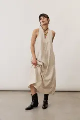 Vestido largo marrón, sin mangas, con cuello halter y bolsillos laterales.