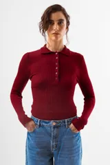 Top de tejido de punto acanalado color bordó, de manga larga y cuello polo con botones frontales.