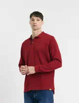 Remera de manga larga con cuello polo, confeccionada en tejido de punto canalé francés. Presenta abotonadura frontal con botones de madera y detalles a contratono en la cartera y el interior del cuello.
