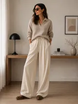 Botín tipo Chelsea de cuero metalizado en tono bronce, con paneles elásticos laterales en color beige. Presenta detalles de costuras decorativas tipo brogue en la puntera y laterales, con suela de goma antideslizante y taco bajo foliado.