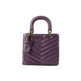 Cartera tipo tote de tamaño mediano en color púrpura, con diseño acolchado en forma de V. Cuenta con doble asa de mano rígida, correa regulable extraíble, herrajes dorados y cierre principal.