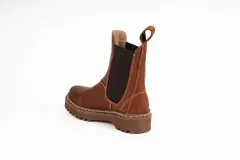 Bota de caña baja tipo chelsea de cuero encerado color terracota, con elásticos negros en los laterales, costuras visibles y suela track marrón con plataforma dentada.