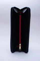 Billetera rectangular con cierre perimetral, confeccionada en cuero con textura de reptil. Cuenta con múltiples compartimentos internos para tarjetas, documentos y billetes, además de un bolsillo interior con cierre para monedas.