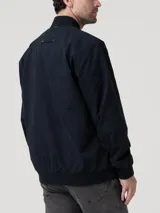 Chaqueta tipo bomber color azul marino, con cierre frontal completo, cuello, puños y pretina en rib. Cuenta con bolsillos laterales y forro interior de franela.