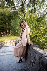 Pollera midi de corte amplio y diseño tipo bomber, con cintura alta y ajuste mediante lazo, confeccionada en tela de color beige.