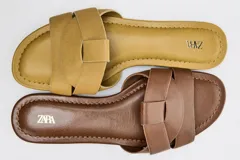 Sandalias planas de piel color marrón, con diseño de tiras cruzadas en la parte delantera y suela baja.