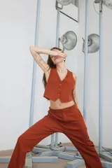 Chaleco color ladrillo de tela sastrera con forrería de poplín de algodón a tono, escote en V y cierre frontal con botones.