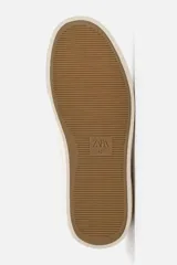 Zapatilla de cordones color beige, con parte superior lisa, horma redonda, forro interior a contraste y suela con ligera textura.