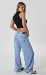 Pantalón de jean tiro bajo con corte wide leg y diseño de cinco bolsillos. Presenta un lavado celeste claro y cierre frontal con botón metálico.
