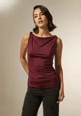 Top sin mangas color bordó, confeccionado en poliamida, con cuello recto y detalle de frunces laterales que le otorgan un ajuste al cuerpo.