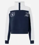 Buzo tipo polo de textura waffle con diseño color block en blanco y azul marino. Presenta cuello alto con cierre de botones, mangas largas y bordados decorativos en el frente.