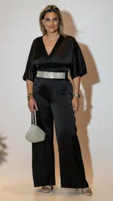 Mono largo negro de satén con escote cruzado, mangas cortas tipo kimono, cinturón plateado con strass y pantalón palazzo.