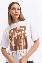 Remera de algodón color marrón con estampa gráfica frontal en tonos oscuros y texto.