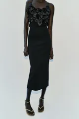 Vestido midi negro de punto con tirantes finos, escote recto adornado con aplicaciones de flores tridimensionales de tela satinada y abertura en la espalda.