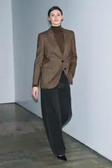 Blazer de Zara confeccionado en hilatura con lana, con diseño de espiga en tonos marrones. Presenta cuello solapa, manga larga con botones, bolsillo de vivo en el pecho y bolsillos delanteros con solapa. Cierre frontal con botones y forro interior negro.
