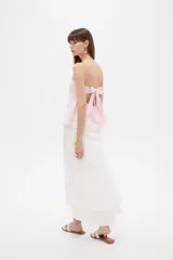 Top strapless de poliéster color rosado, con diseño holgado y elástico superior.