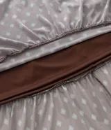 Falda midi de tul con estampado de corbatas, cintura elástica y diseño con volados. Presenta un forro más corto que crea un efecto de transparencia en el ruedo.