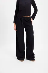 Pantalón de jean negro de corte recto y pierna ancha, con cintura elástica ajustable mediante cordón. Presenta costuras en contraste color cobre.