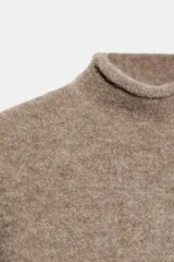 Jersey de punto de tacto suave, color gris jaspeado, con cuello subido y manga corta.