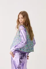 Chaleco capitoneado con estampado floral y terminación metálica.