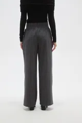 Pantalon de vestir de corte recto y tiro alto, confeccionado en tela de viscosa con diseño de rayas verticales finas en color blanco sobre fondo negro.