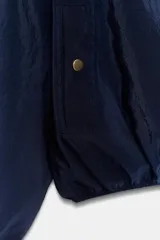 Cazadora tipo bomber de cuello redondo y manga larga con puños elásticos. Presenta cierre frontal con cremallera metálica, bolsillos laterales de vivo con botón a presión y bajo con ajuste elástico.