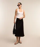 Pollera midi evasé de color beige claro, confeccionada en tela satinada de poliéster.
