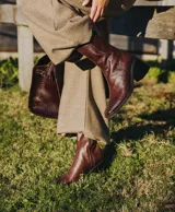 Bota de cuero vacuno color marrón con cierre lateral, taco de madera de 7cm y caña de 19cm.