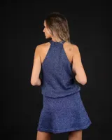 Top de escote halter confeccionado en tejido brillante con acabado de lentejuelas. Presenta espalda descubierta con lazos regulables para un ajuste personalizado y caída fluida.