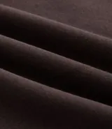 Buzo de corte holgado tipo ballon, color marrón oscuro, con cuello alto y cierre frontal parcial. Presenta mangas largas con puños elásticos y cordón ajustable en el ruedo.