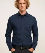 Camisa masculina de manga larga, cuello inglés y cierre frontal de botones, confeccionada en poliamida con elastano y tecnología performance.