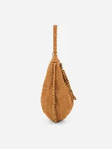 Bolso tipo hobo de gran tamaño, confeccionado en gamuza negra con detalles de costuras artesanales y tientos decorativos en los bordes. Cuenta con un asa trenzada con pespuntes a mano y cierre superior.