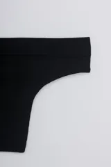 Colaless de tiro bajo confeccionada en tejido de punto rib, con diseño seamless sin costuras laterales.