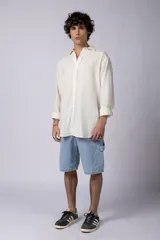 Camisa de manga larga color crema, confeccionada en lino, con cuello clásico y corte holgado.