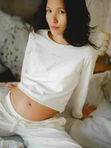 Conjunto de pijama blanco de algodón, compuesto por una remera de manga larga con detalle de encaje en el ruedo y un pantalón largo de corte holgado con cintura elástica ajustable.
