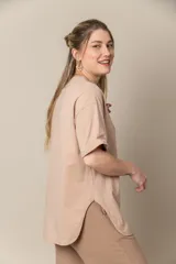 Remera blanca de algodón con cuello redondo y mangas cortas. Estampa frontal con fotografía en blanco y negro de una mujer con toalla en la cabeza y lentes de sol.