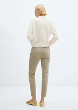 Pantalon de corte skinny en color beige, confeccionado en mezcla de algodón. Presenta un diseño crop con botones decorativos en la parte frontal, cierre oculto de cremallera y gancho, bolsillos laterales y bolsillos de ribete en la parte posterior.