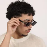 Lentes de sol con armazón metálico plateado y cristales oscuros de forma ovalada. Cuentan con protección UV400.