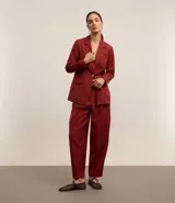 Pantalón de vestir color borgoña, de corte zanahoria, con pliegues delanteros, cierre con solapa y cremallera oculta.