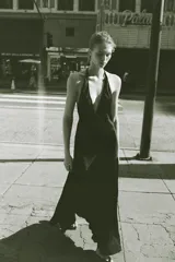 Vestido midi de satén color negro, con cuello halter y cierre de lazada en la nuca. Presenta un diseño fluido con frunces en el escote y corte a la cintura.