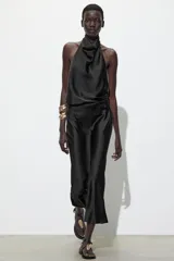 Top blanco satinado con cuello halter y escote fluido. Cierre en la espalda con botones.