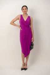 Vestido midi al cuerpo de color fucsia, con escote cruzado en V, sin mangas y falda asimétrica con detalle de drapeado frontal.