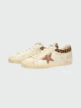 Zapatillas Golden Goose modelo Super Star, de diseño desgastado, con estrella lateral en gamuza marrón y detalle de animal print en el talón.