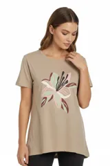 Remera de algodón color beige con cuello redondo, manga corta y corte holgado. Presenta un estampado floral central en tonos verdes, rosados y bordó.