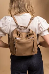 Cartera mochila versátil de cuero sintético con textura granulada, color negro. Cuenta con múltiples bolsillos frontales con cierre, correas ajustables que permiten su uso tanto como cartera de hombro o como mochila, y herrajes metálicos.